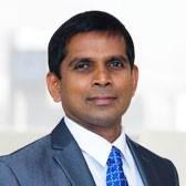 Portrait of Aruna Jayasekera in a suit and tie