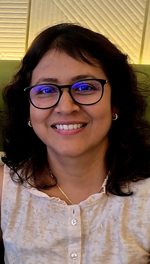 Portrait of Kumudini Kariyawasan smiling in a pink dress